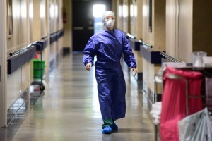 A medical worker wearing a face mask and gear walks across a unit of the Brescia Poliambulanza hospital, Lombardy, on March 17, 2020. (Photo by Piero CRUCIATTI / AFP)